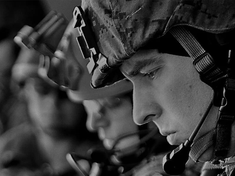 A young soldier in a helmet and headset, in black and white