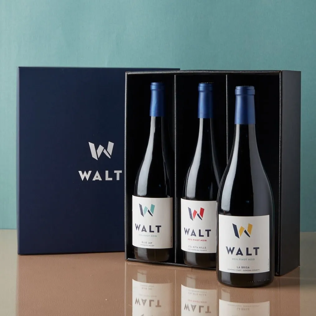 A navy WALT gift box holding three bottles